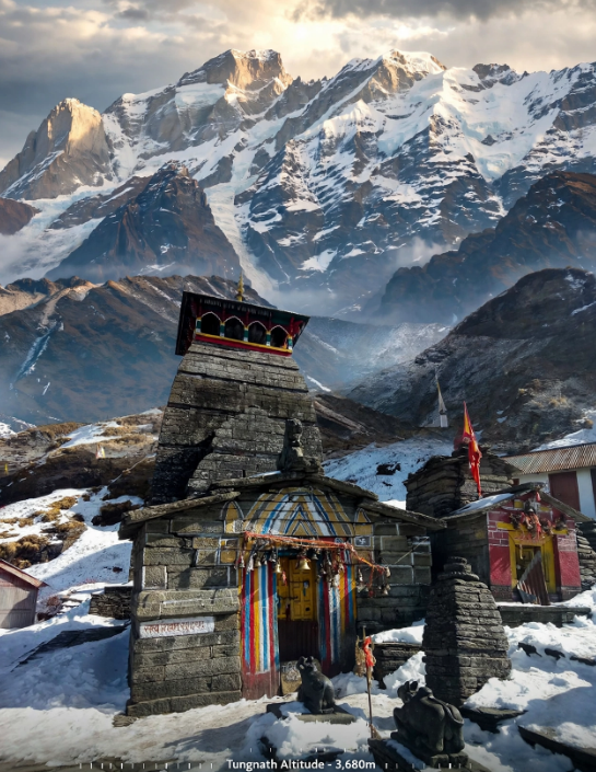 Tungnath Temple during winter trek with snow-covered trail and Himalayan peaks in the background.